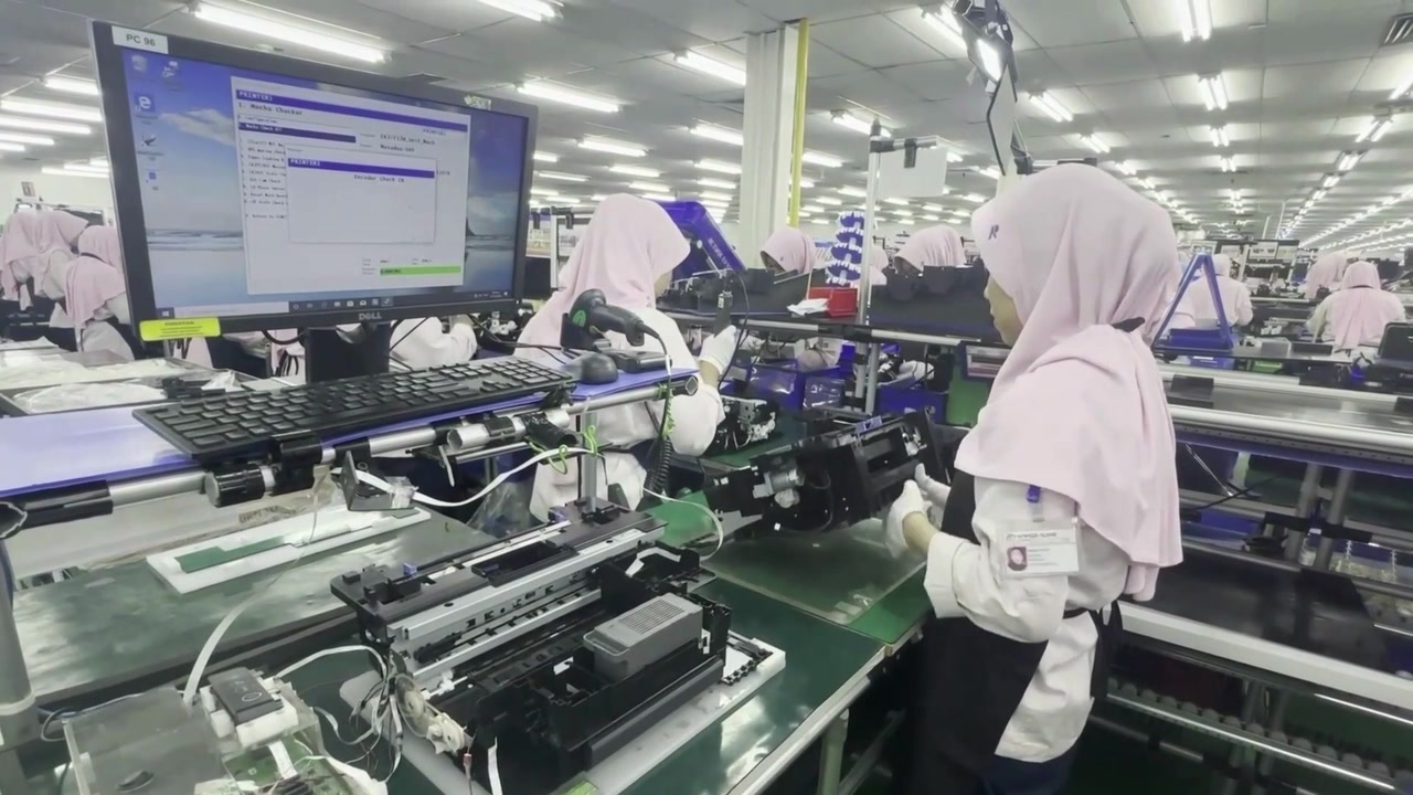 An operator assembling a mechanism at a Kiyokuni assembly workstation