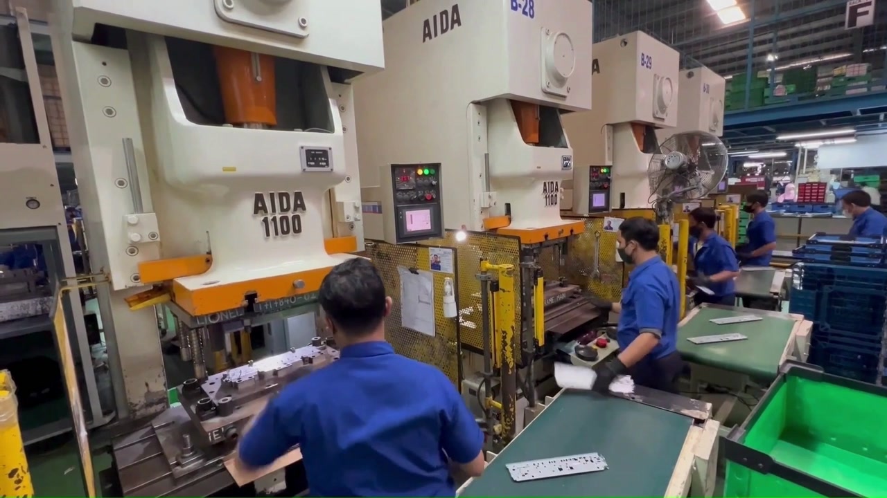 An operator working at a press machine in the Kiyokuni production area