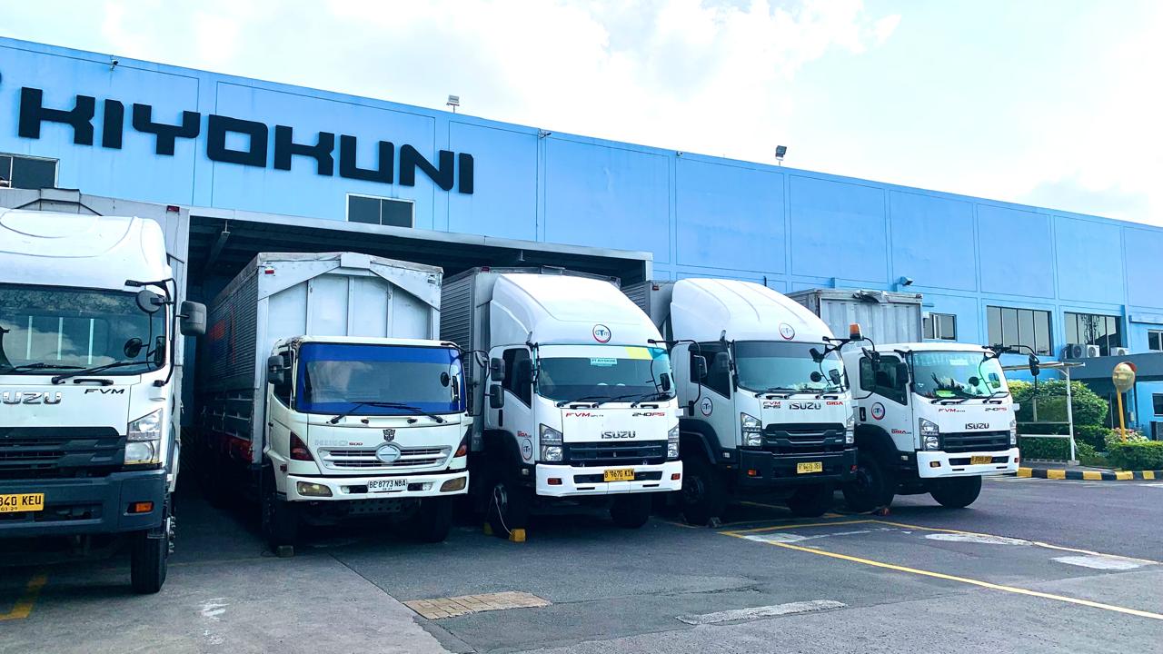 Delivery trucks at the loading area in front of the Kiyokuni Indonesia factory