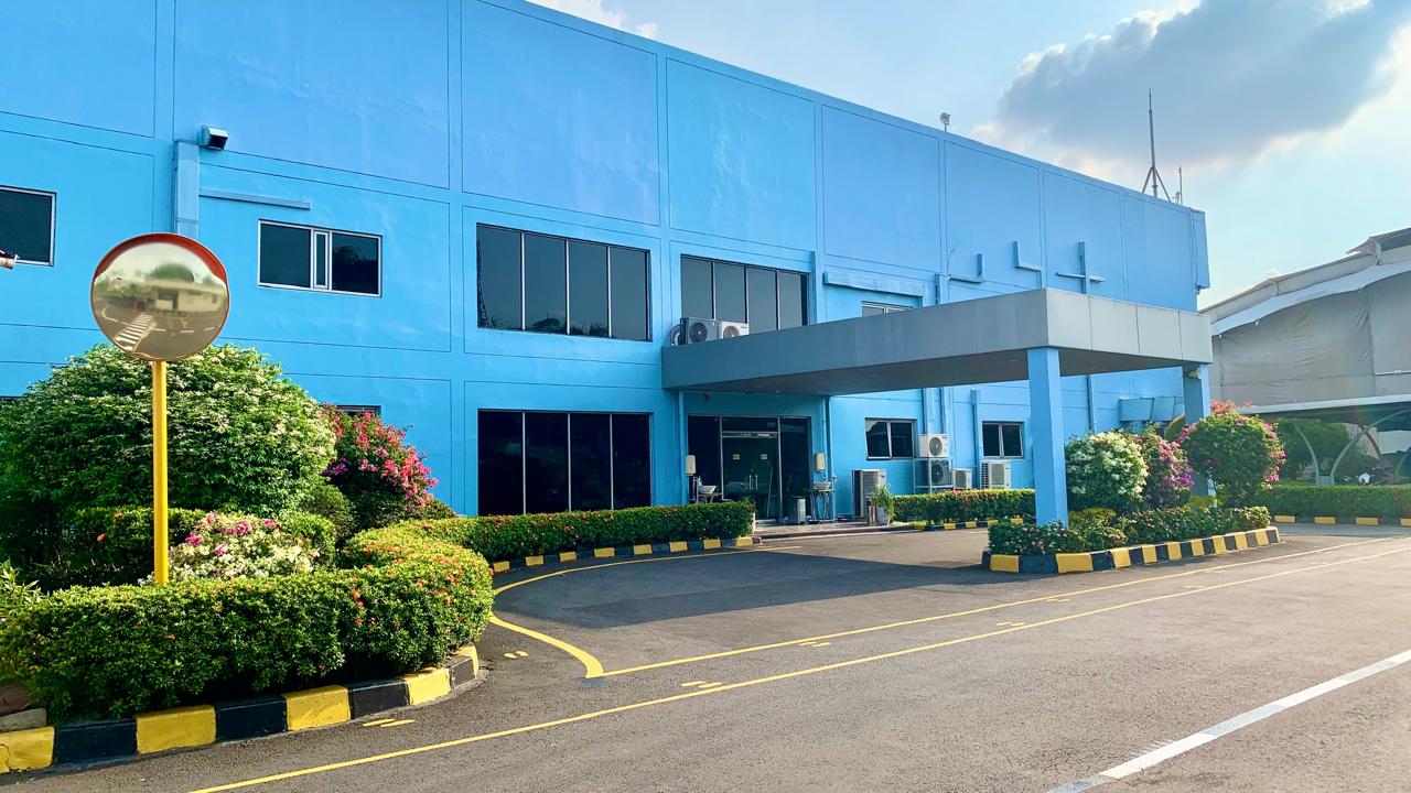 The blue Kiyokuni Indonesia factory building, main entrance and landscaped grounds
